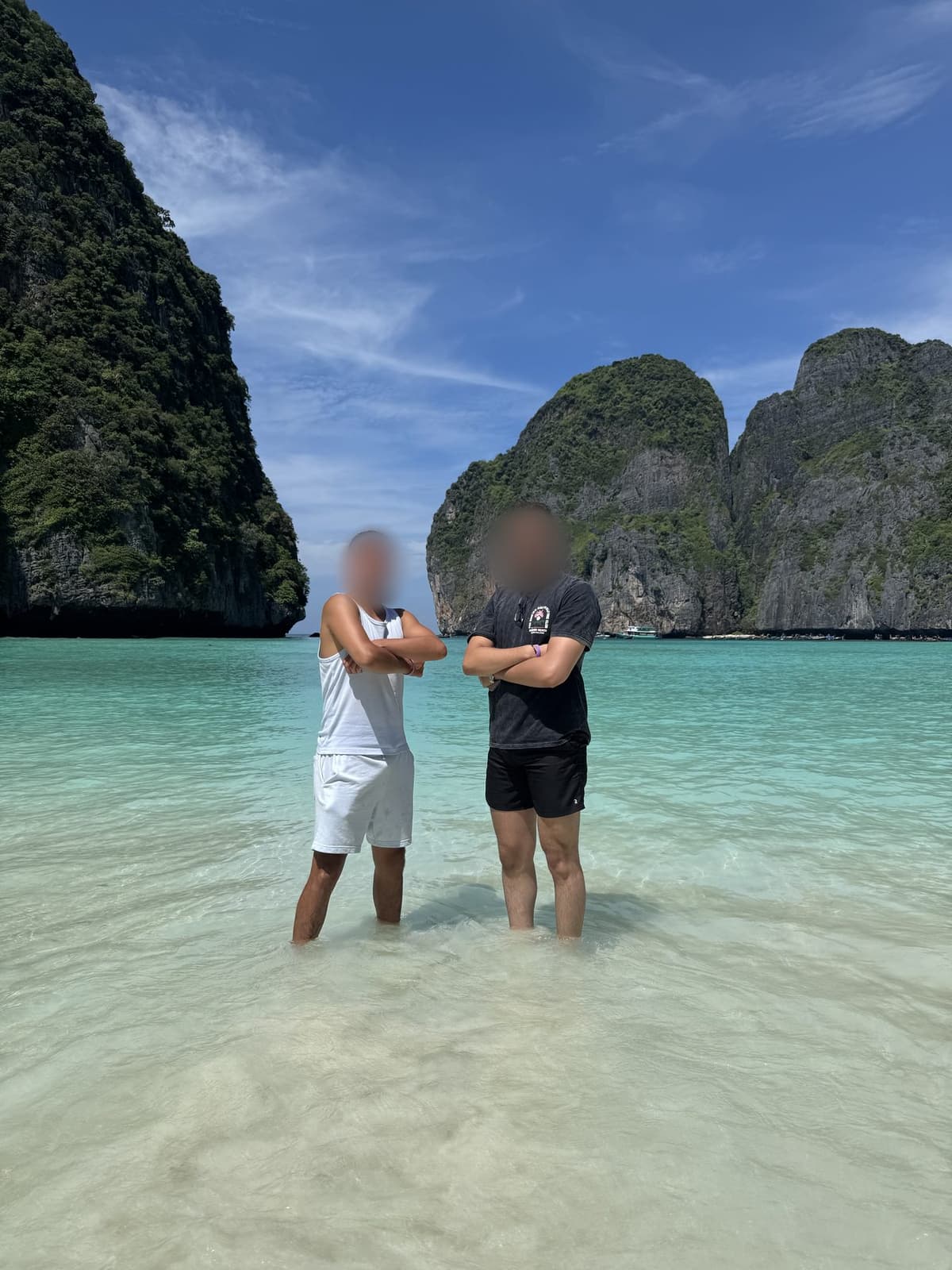 Two friends standing in turquoise water between tall cliffs