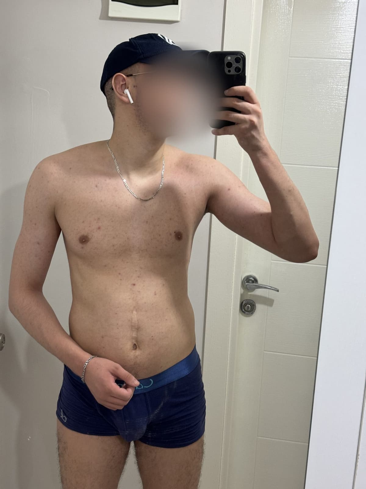 Day 105 at 85 kg, shirtless mirror photo with a cap, fuller chest and shoulders